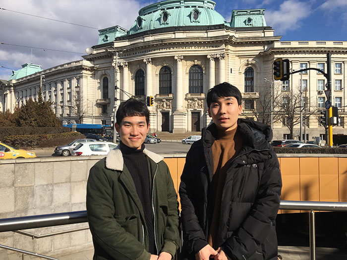  
Kim Yeon-su (left) and Moon Jong-hyo (right) stand in front of Sofia University, the most prestigious institution of higher learning in Bulgaria. 
